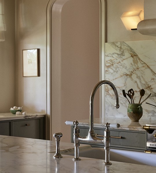 Best polished nickel kitchen tap, traditional sink mixer with porcelain handles, over a sink in marble bench.