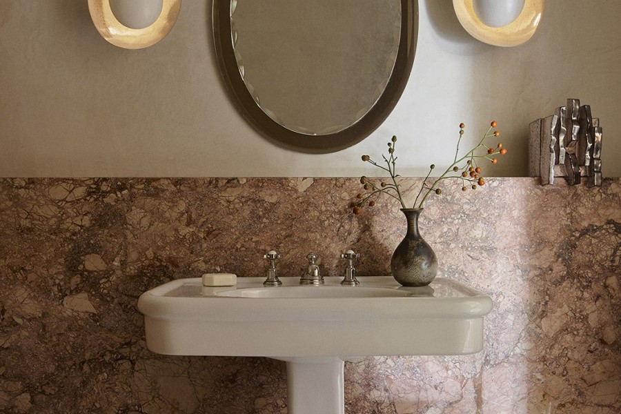 A powder room with bold pink marble wall with pedestal sink from The English Tapware Company and Polished Nickel heritage Perrin & Rowe separate hot and cold taps.