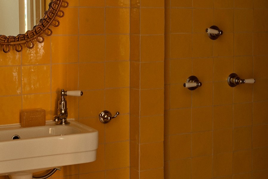 A WC with golden grid tiles with powder-room sink from The English Tapware Company and Polished Nickel heritage Perrin & Rowe separate hot and cold taps.