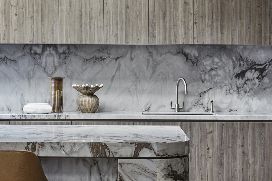 The Perrin & Rowe Oberon contemporary kitchen tap with twin levers in pewter finish sits proudly on thick marble benchtop.
