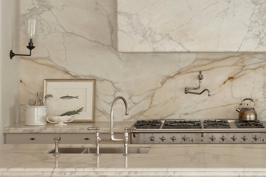 A Perrin & Rowe Ionian Tap two-hole mixer with spray rinse and Pot Filler, both in polished nickel sits in marble kitchen. 