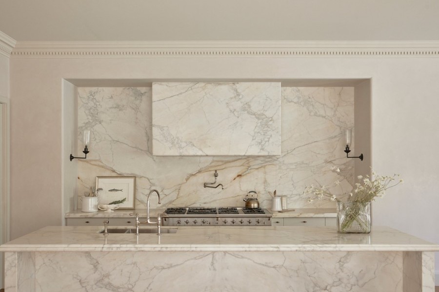 A Perrin & Rowe Ionian Tap two-hole mixer with spray rinse and Pot Filler, both in polished nickel sits in marble kitchen. 