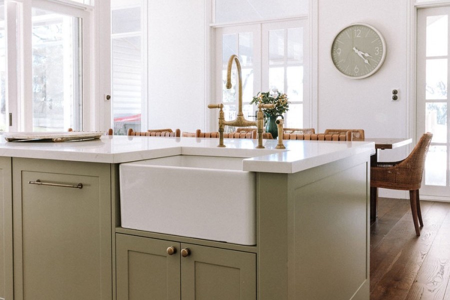 In the kitchen, the Perrin & Rowe Ionian two-hole bench-mounted mixer with white porcelain levers and spray rinse in polished brass adds traditional charm, complementing the natural finishes and warm palette. 