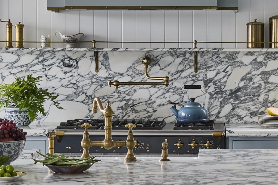 A Perrin & Rowe Provence Tap and Pot Filler, both in polished brass sits in marble kitchen. 