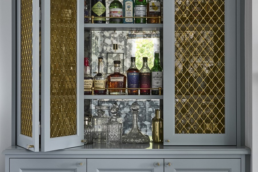 Oxford Grilles in a diamond pattern with plain rosettes also in polished brass are continued into the living room custom bar joinery