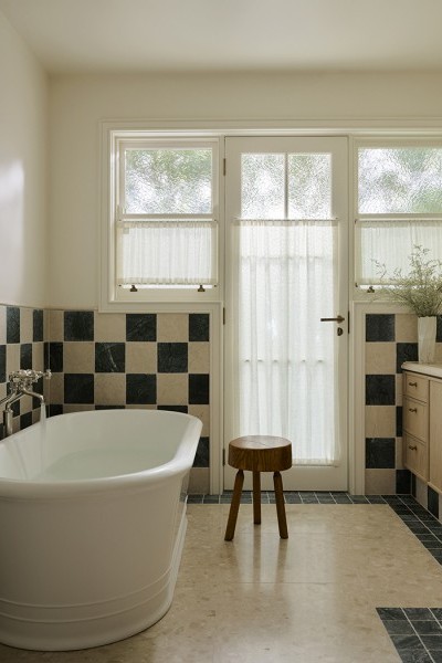 Green and taupe checkerboard tiled bathroom with Joseph Giles door hardware and Perrin & Rowe heritage tapware. 