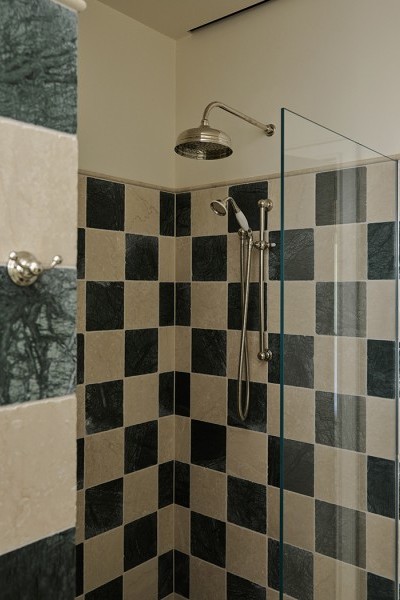 Green and beige checkered tile shower with Perrin & Rowe traditional shower with white porcelain handle. The wall nearby features the double robe hook from Perrin & Rowe.