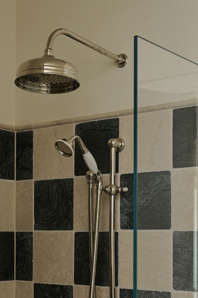 Green and neutral checkerboard tiled shower with Perrin & Rowe traditional shower with white porcelain handle. 