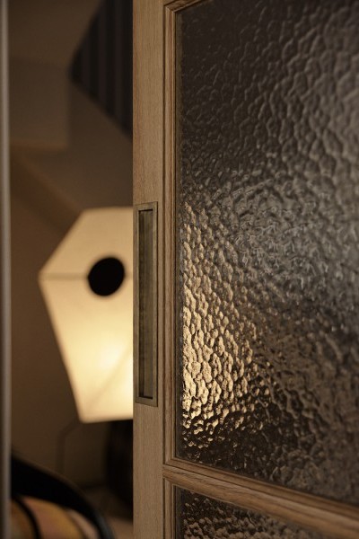 A sliding timber and glass door with a Joseph Giles rectangular solid brass recessed pull from The English Tapware Company.