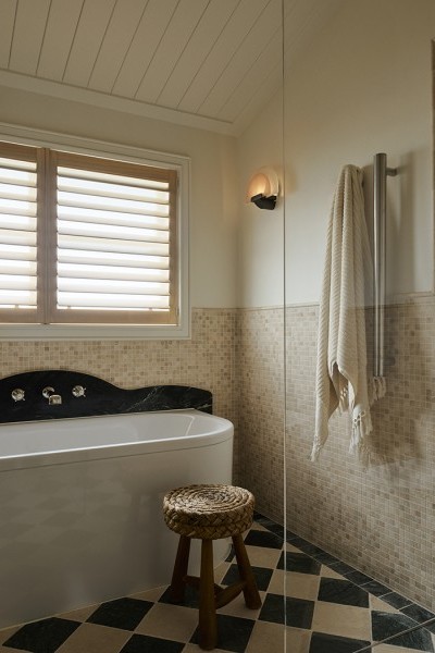 A white bath with Perrin & Rowe polished nickel wall-mounted bath mixer with low spout & crosshead taps. 