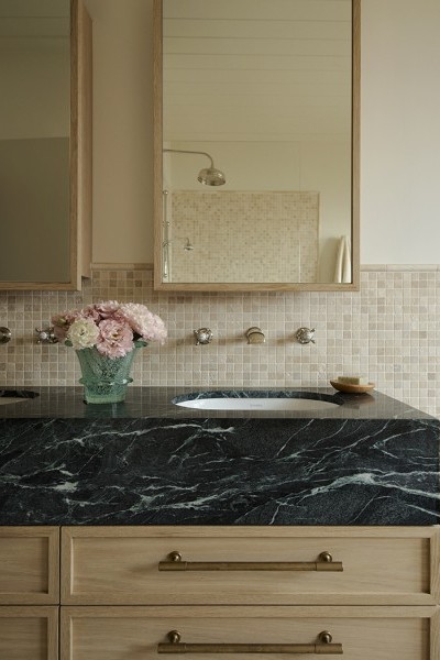 A green marble vanity featuring Perrin & Rowe wall mounted traditional taps and mixer and aged brass cabinet pulls from Armac Martin. 