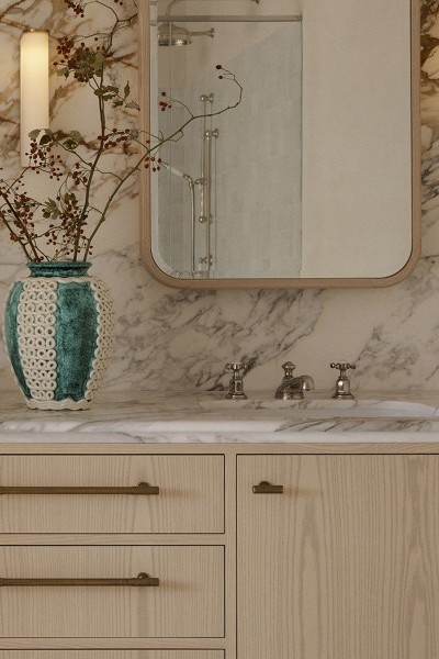 A timber vanity with marble surface showcases Perrin & Rowe classic hot and cold taps with a sink mixer. 