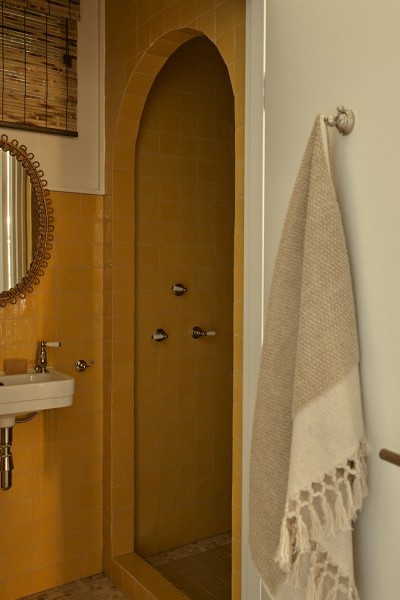 A bathroom with yellow zellige tiles with small white Deco style Soho basin from The Water Monopoly and Polished Nickel traditional Perrin & Rowe tapware.