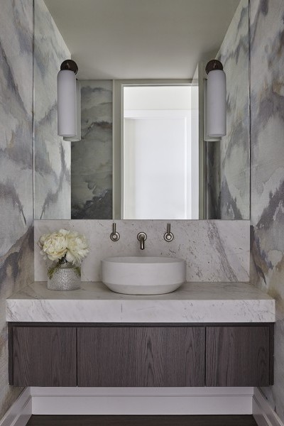 Large mirror reflects Marshmallow Manilla Hemp wallpaper above a stone basin and modern pewter plated brass tapware.

