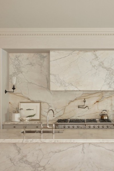 A Perrin & Rowe Ionian Tap two-hole mixer with spray rinse and Pot Filler, both in polished nickel sits in marble kitchen. 