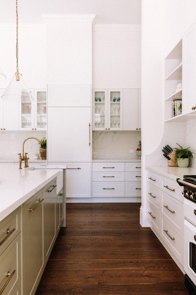 In the kitchen, the Perrin & Rowe Ionian two-hole bench-mounted mixer with white porcelain levers and spray rinse in polished brass adds traditional charm, complementing the natural finishes and warm palette. 