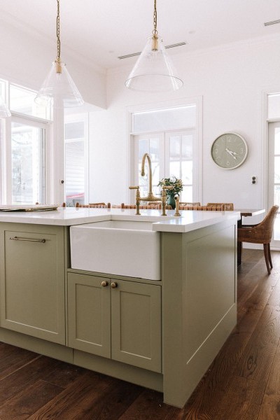 In the kitchen, the Perrin & Rowe Ionian two-hole bench-mounted mixer with white porcelain levers and spray rinse in polished brass adds traditional charm, complementing the natural finishes and warm palette. 