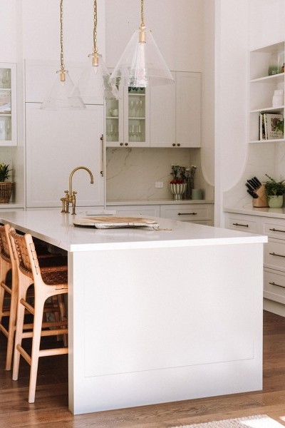 In the kitchen, the Perrin & Rowe Ionian two-hole bench-mounted mixer with white porcelain levers and spray rinse in polished brass adds traditional charm, complementing the natural finishes and warm palette. 