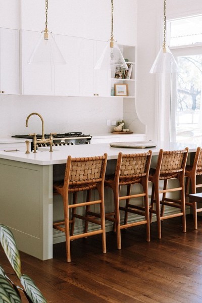 In the kitchen, the Perrin & Rowe Ionian two-hole bench-mounted mixer with white porcelain levers and spray rinse in polished brass adds traditional charm, complementing the natural finishes and warm palette. 
