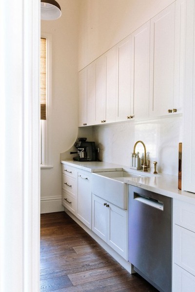 The laundry features the Perrin & Rowe Phoenician one-hole sink mixer in the same finish, continuing the classic detailing through functional spaces.