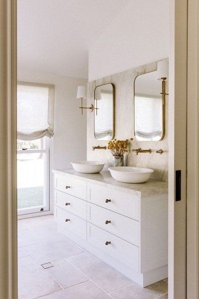 In the bathroom, polished brass Perrin & Rowe tapware and matching accessories bring cohesion and elegance, paired with Victoria & Albert freestanding baths and basins for a refined, luxurious feel. 
