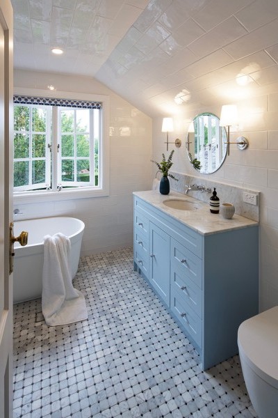 Chrome Art Deco bathroom taps, chrome toilet flush plate and chrome accessories in attic bathroom with pale blue vanity.
