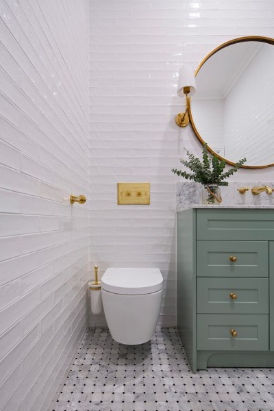 Polished brass Aquadomo toilet flush plate for concealed in-wall cisterns adds to the brass accents in modern bathroom.