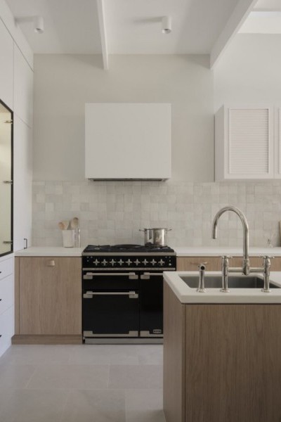 Timber kitchen with white tiled splash back, white cabinetry and nickel kitchen tap and spray. 