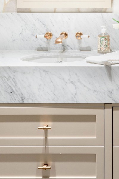 Elegant bathroom styled with traditional brass taps, a brass towel rail, and brass t-bar drawer handles.
