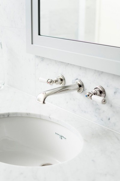 Close up of traditional wall mounted basin tap set and counter sunk basin by Perrin in Rowe installed in designer bathroom.

