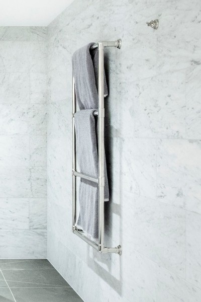 Modern wall-mounted four rung electric towel warmer in chrome finish is mounted on marble wall in Melbourne ensuite.
