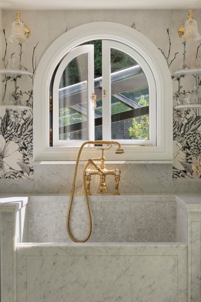 In the laundry, the use of a polished brass Perrin & Rowe bath mixer with hand shower and crosshead taps is cleverly used to introduce a refined sense of luxury to a traditionally utilitarian space. 