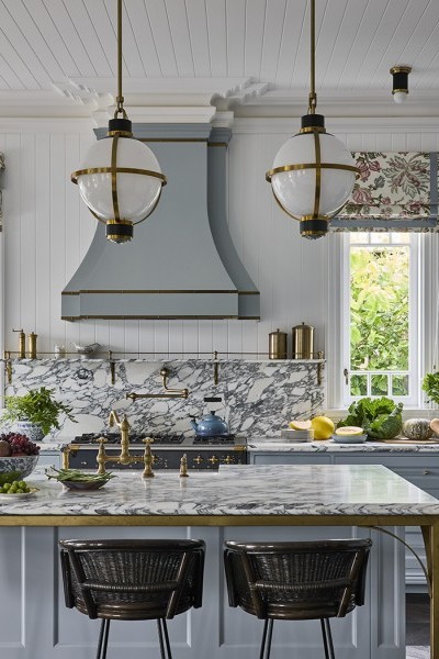 A Perrin & Rowe Provence Tap and Pot Filler, both in polished brass sits in marble kitchen. 