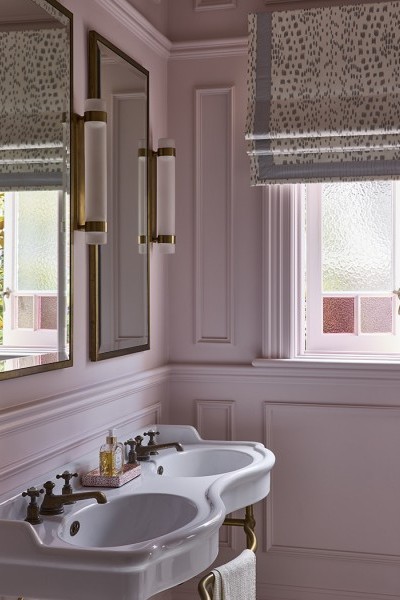 In the master ensuite, The Water Monopoly Paris Double Vanity takes centre stage with its sculptural ceramic form, elegantly raised on brass legs and set against a soft pink backdrop.