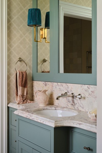 Kids’ bathroom with blue vanity and custom mirror, Perrin & Rowe taps with white porcelain lever handles, and a cohesive, playful design.
