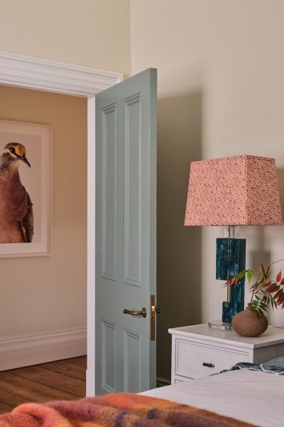 Kids’ bedroom with blue and orange accents that coordinate with the adjoining bathroom, featuring a bed and playful decor.
