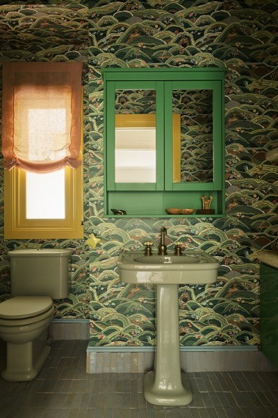 Willow green coloured basin on pedestal in bathroom lined with  Citrus Garden wallpaper by Schumacher.