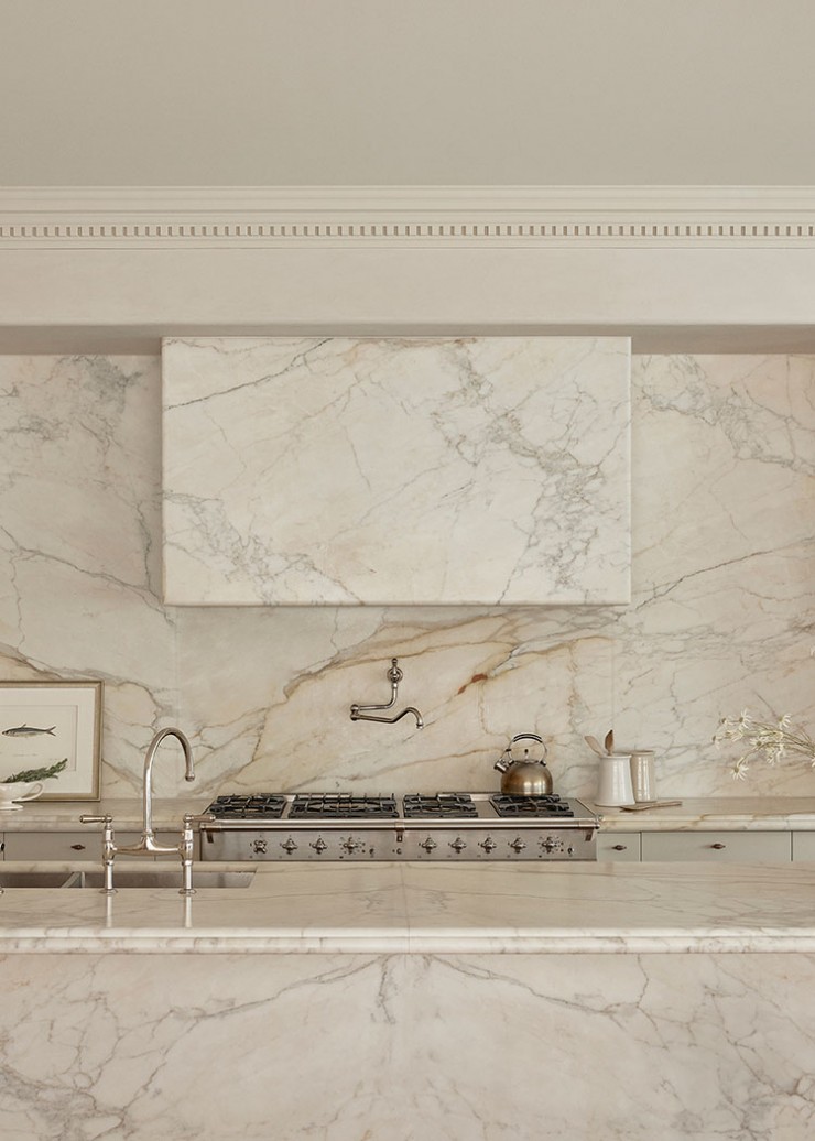 A bridge style tap and wall mounted pot filler offer a high-end luxury functionality to this kitchen