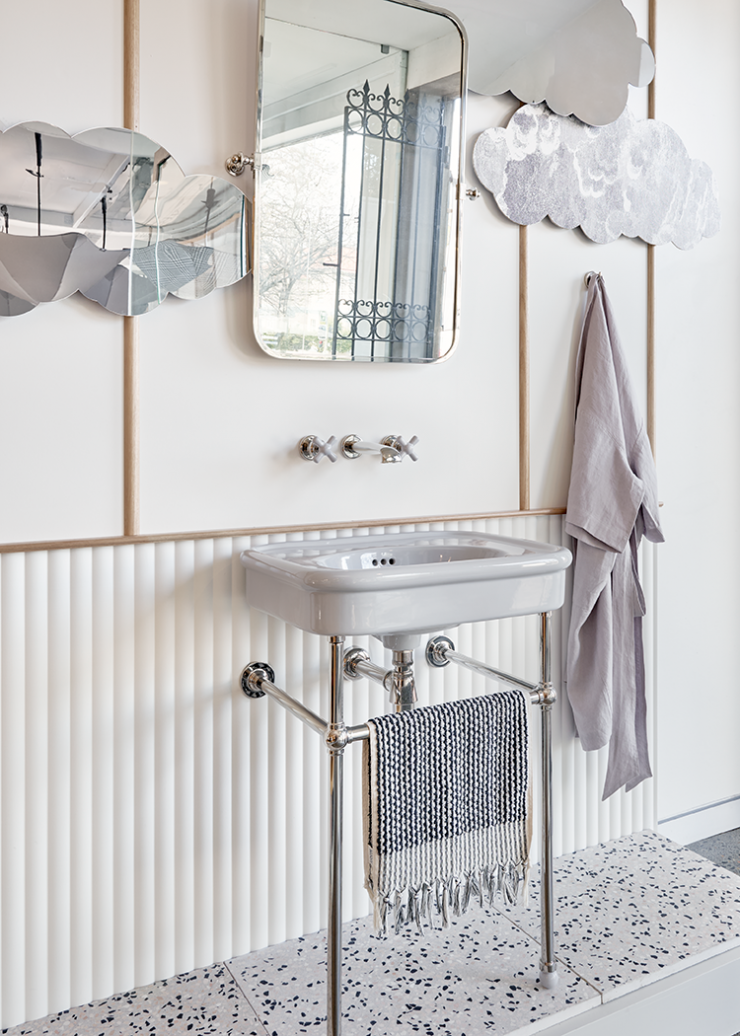 Grey crosshead basin tapware projects over a grey ceramic powder room basin on modern chrome basin stand with ball joints.