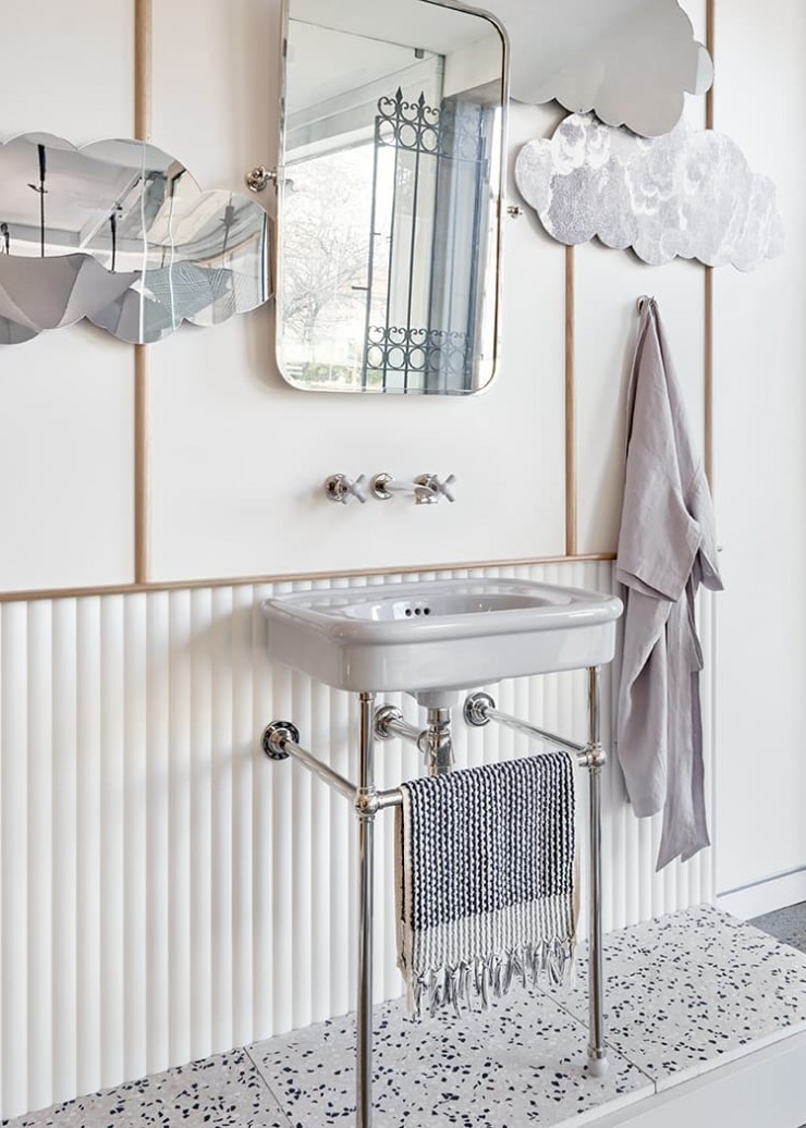 Grey crosshead basin tapware projects over a grey ceramic powder room basin on modern chrome basin stand with ball joints.