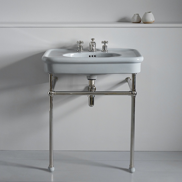 Grey ceramic bathroom wash hand basin with exposed chrome waste pipe on chrome metal basin stand with grey cramic ball feet.